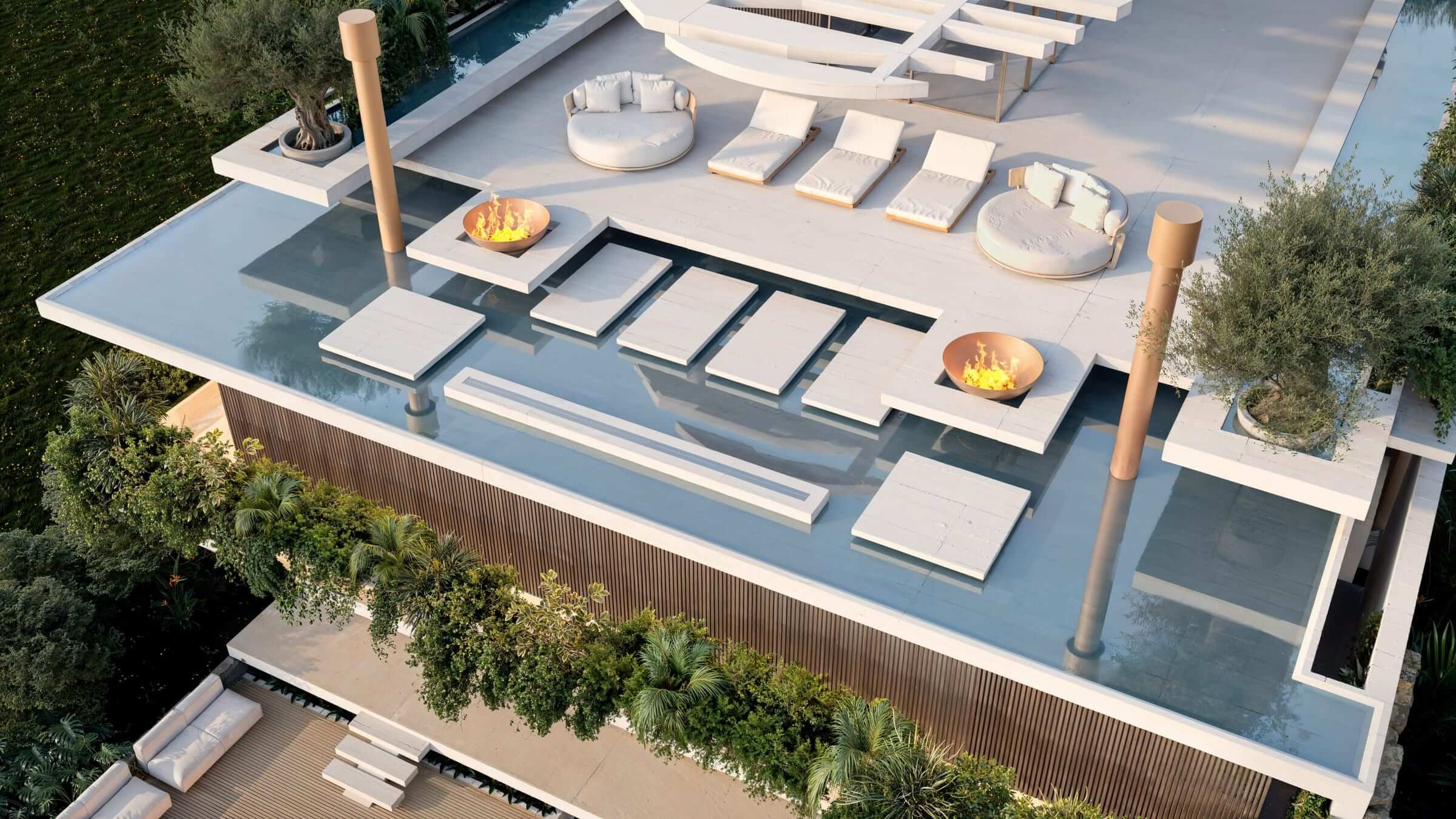 Reflecting pools, lit fire bowls and olive trees among the rooftop loungers.