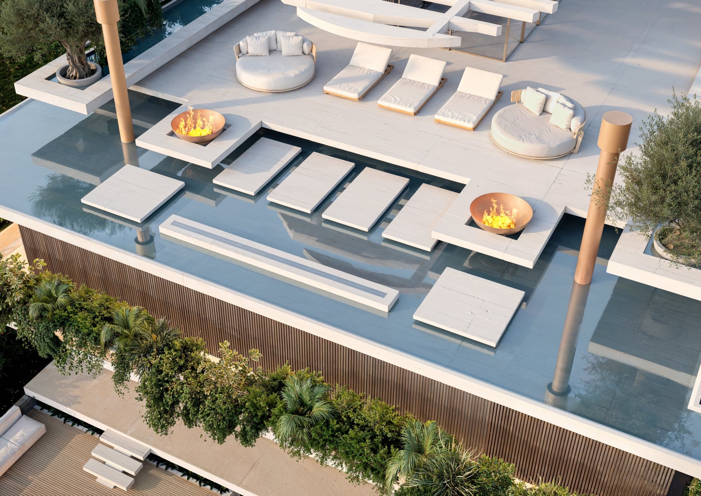 Rooftop sky garden — reflecting pools, fire bowls, olive trees and an open-air cinema over the coastal landscape.